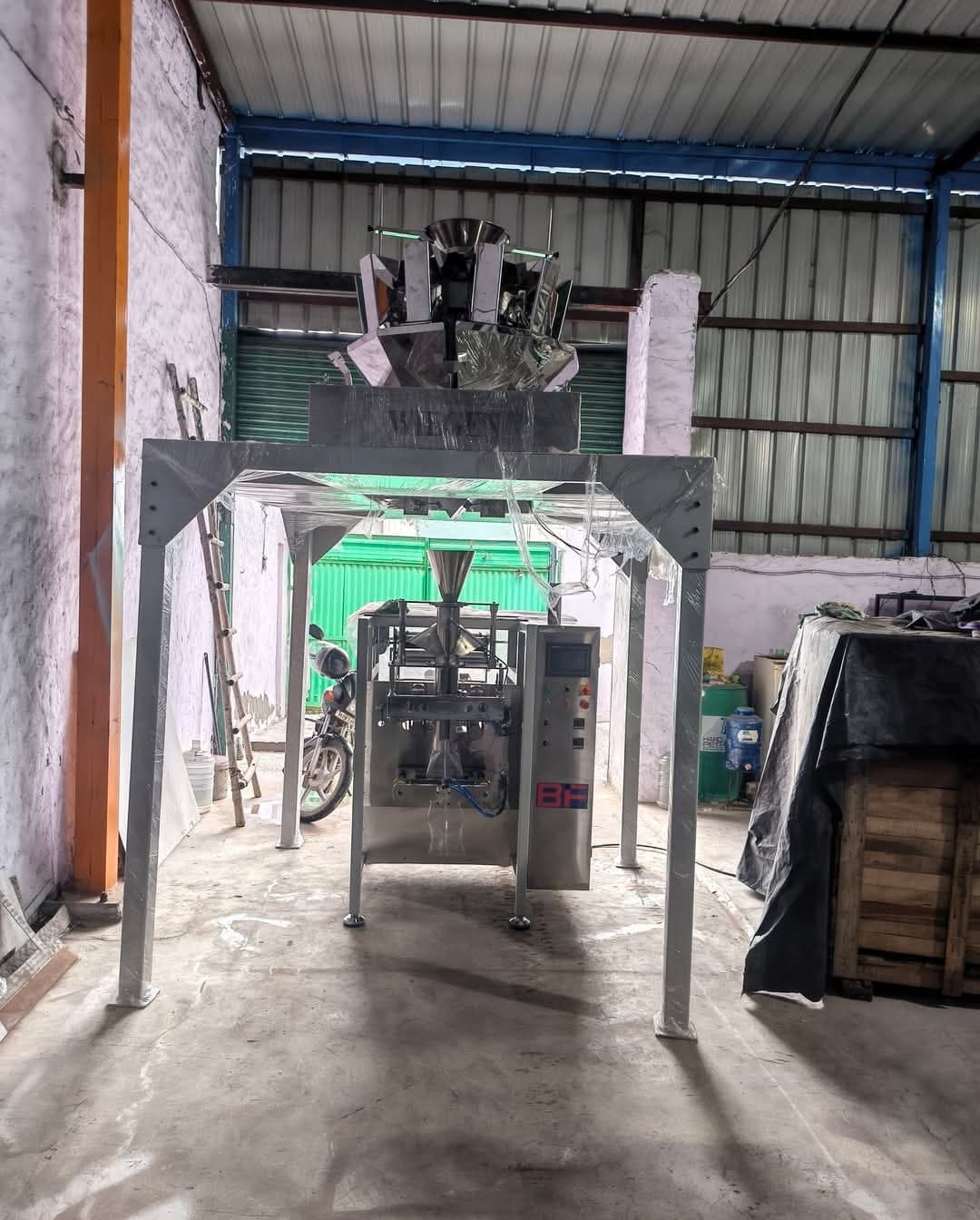 A BF vertical form-fill-seal machine with a multihead weigher on its platform at the Baba Industrial Fabrication works